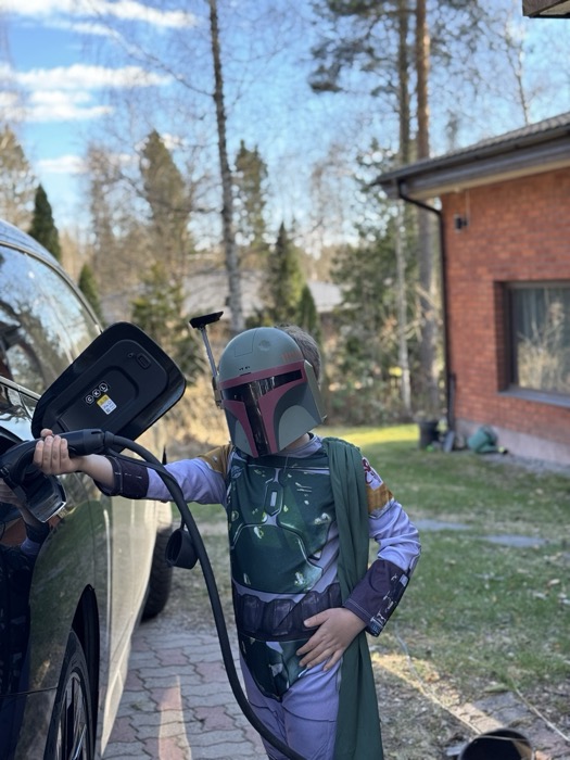 Lapsi lataa sähköautoa kotona
