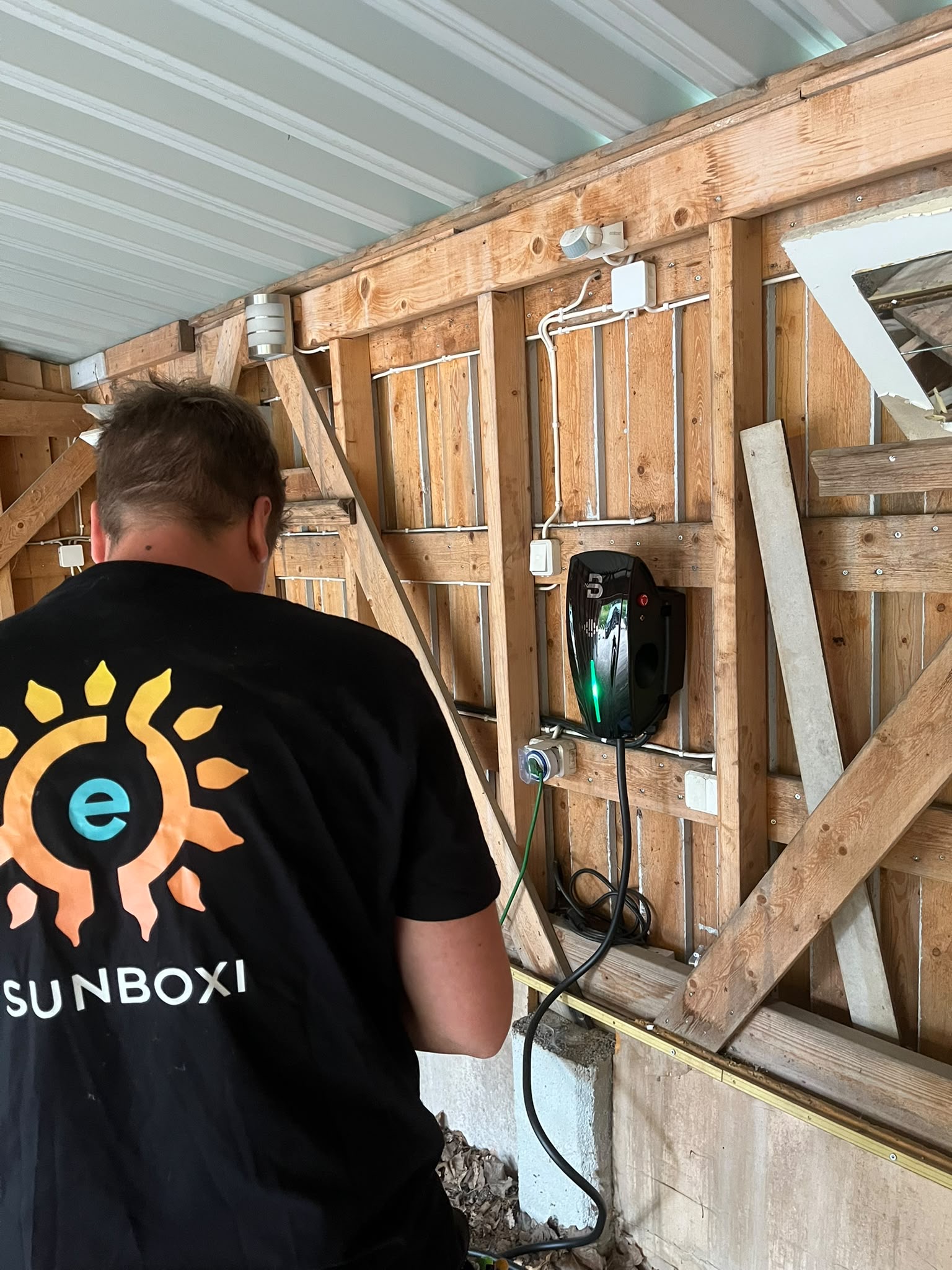 Sunboxin asentaja latausaseman luona